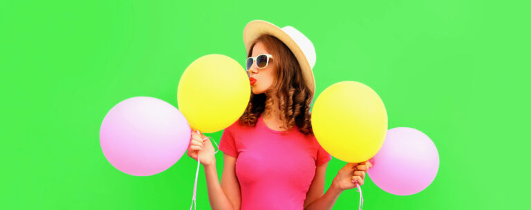 Eine Frau ist super happy und hält Luftballons in der Hand. Sie steht symbolisch für eine Rabatt-Aktion bei camps for friends.